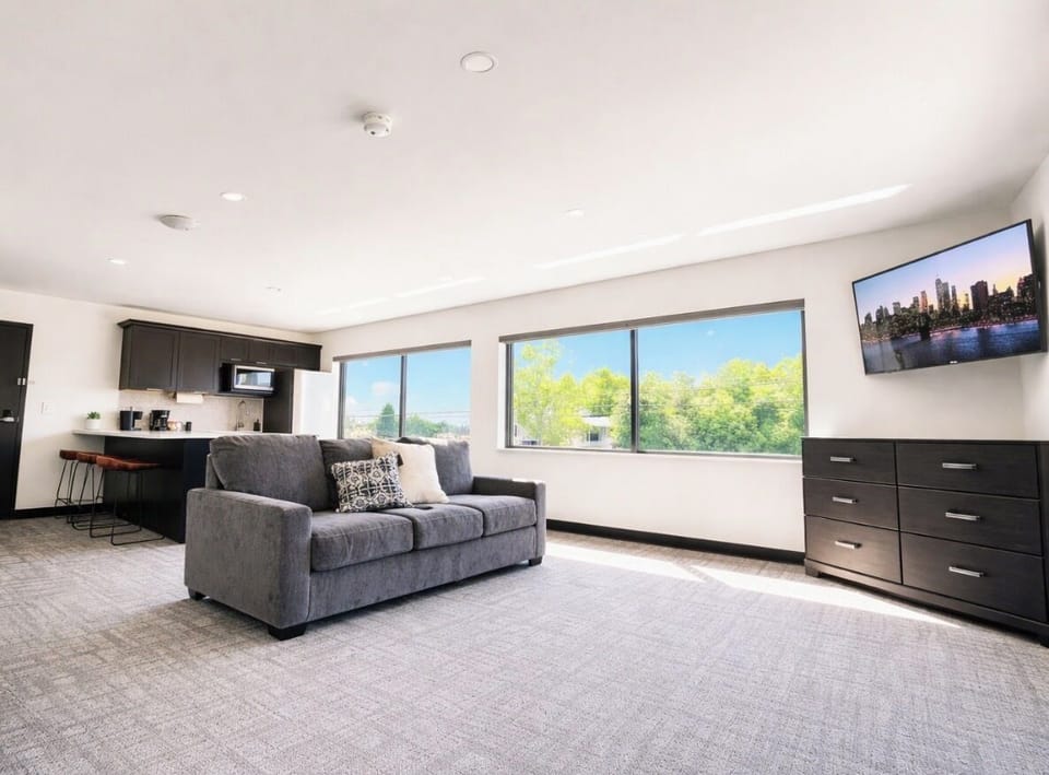 Unwind in this bright corner nook, complete with a dresser and a mounted TV for your favorite shows. Large windows offer plenty of daylight and neighborhood views.
