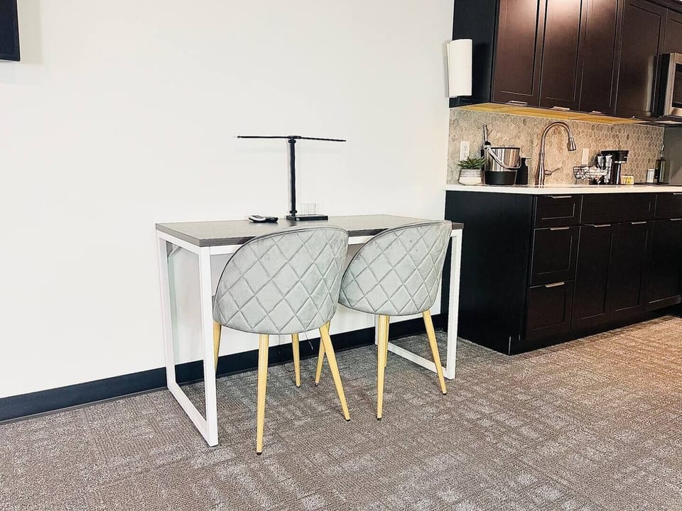 A modern desk setup with an ice bucket, lamp, and remotes, perfect for relaxing or getting work done during your stay.
