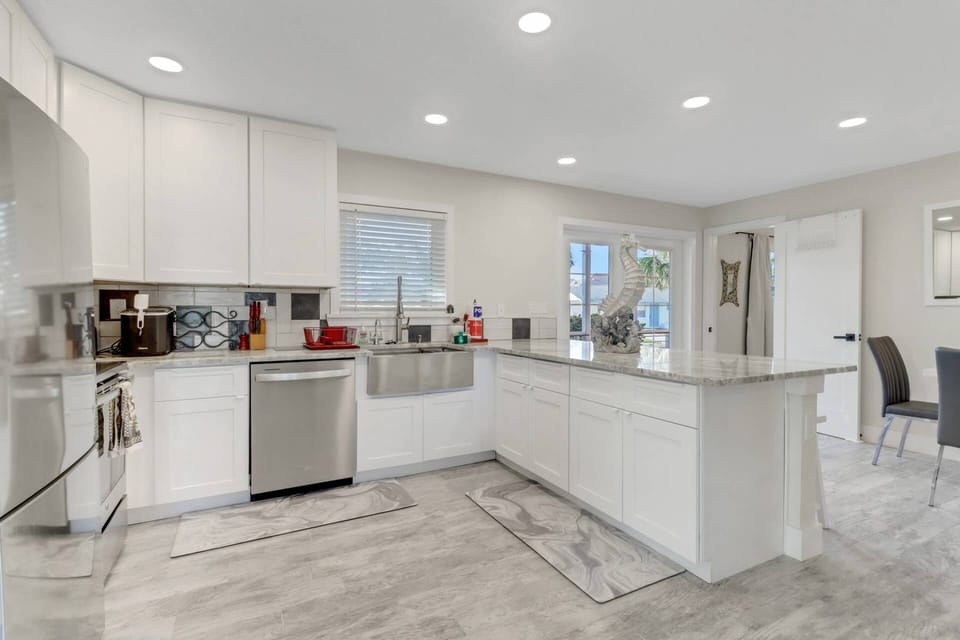 The full kitchen is equipped with upgraded appliances including a refrigerator/freezer, oven, microwave, dishwasher, and farmhouse sink.