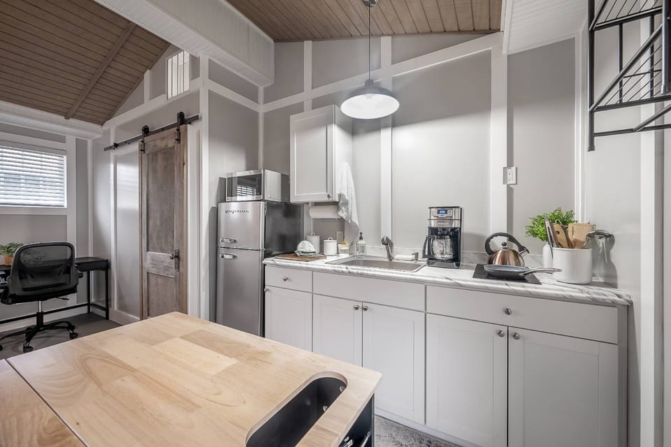 A cozy kitchenette with everything you need for a simple meal complete with a charging station within the moveable wood topped prep island