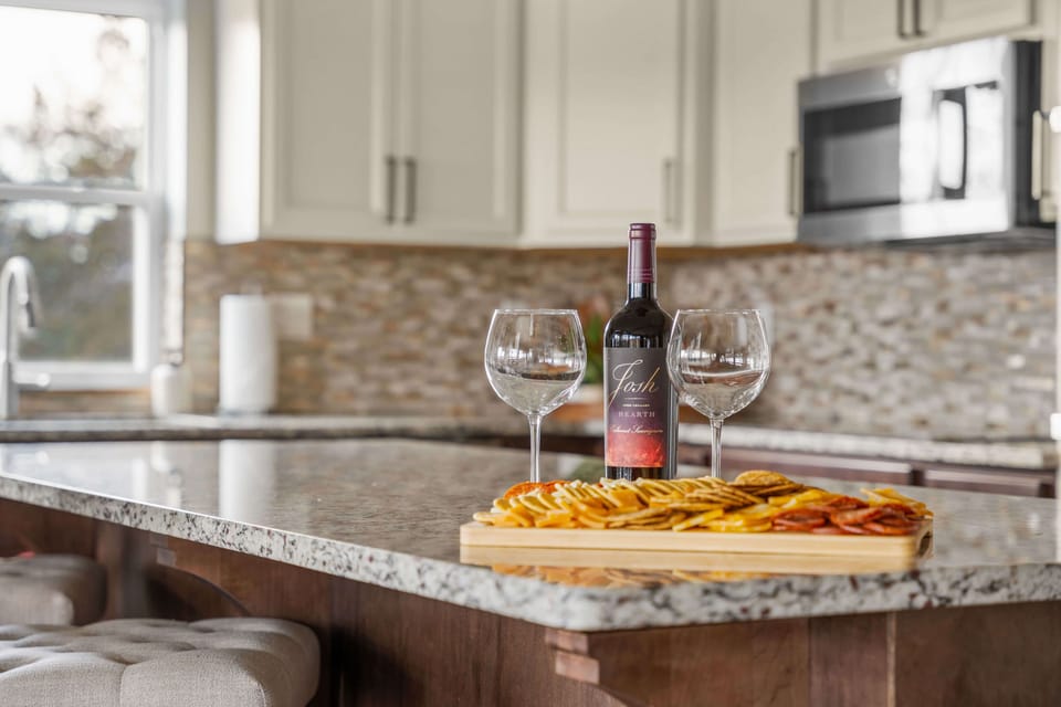 Unwind in style at the kitchen bar, where a welcome wine and glasses await to toast to a perfect getaway. Cheers to relaxation, great company, and unforgettable moments! 🍷✨