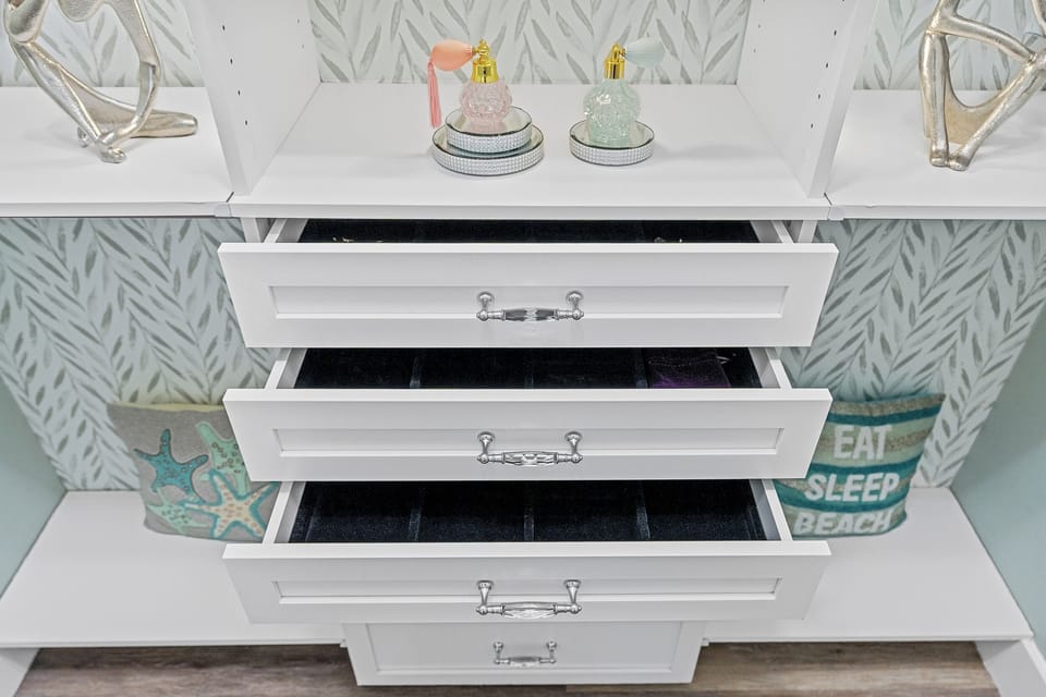 Store your jewelry and keepsakes in this elegant white dresser with organized drawers lined for easy access. Coastal accents and beach-inspired décor complete your space.