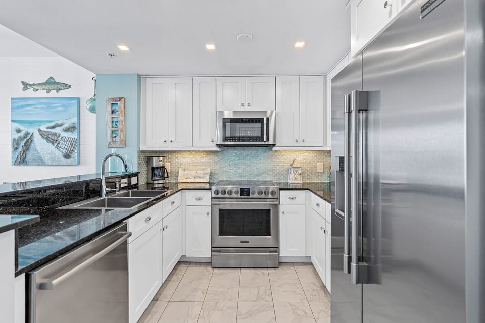 Your fully equipped kitchen features sleek granite countertops, stainless steel appliances, and coastal decor that sets the tone for your beach getaway.