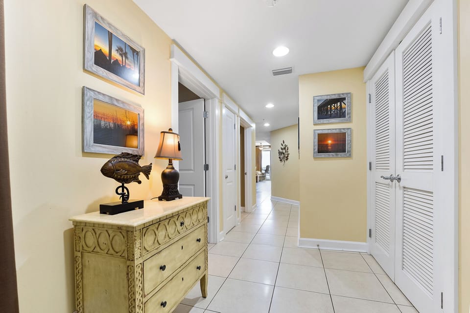 Your elegant hallway welcomes you with coastal artwork and thoughtful lighting, connecting your private spaces seamlessly.