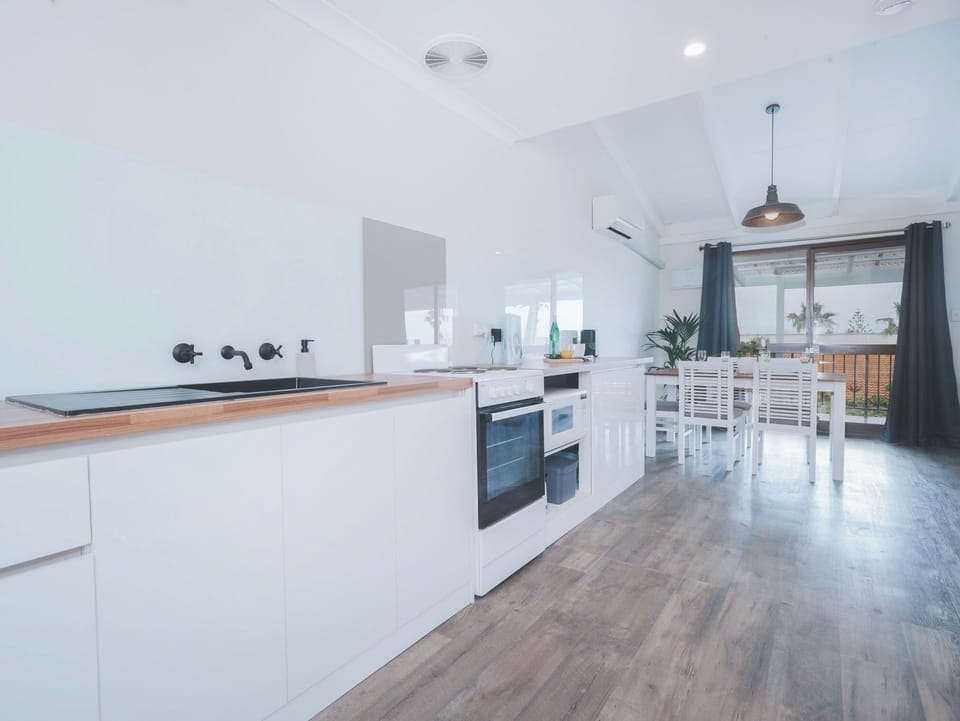Kitchen with the essentials for your stay. Stove, oven, microwave, full fridge, cooking and crockery essentials.