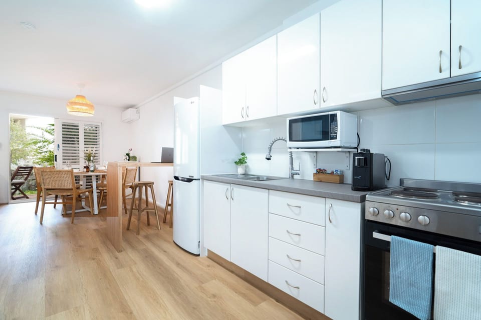 Full kitchen with all the essentials including a full fridge, microwave, stove top and oven plus a piccolo espresso coffee pod machine for your stay.