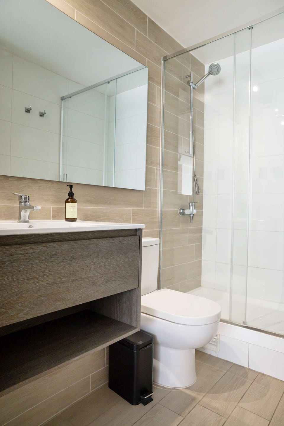 Unwind in this stylish bathroom featuring a spacious shower and sleek design, perfect for a relaxing stay.