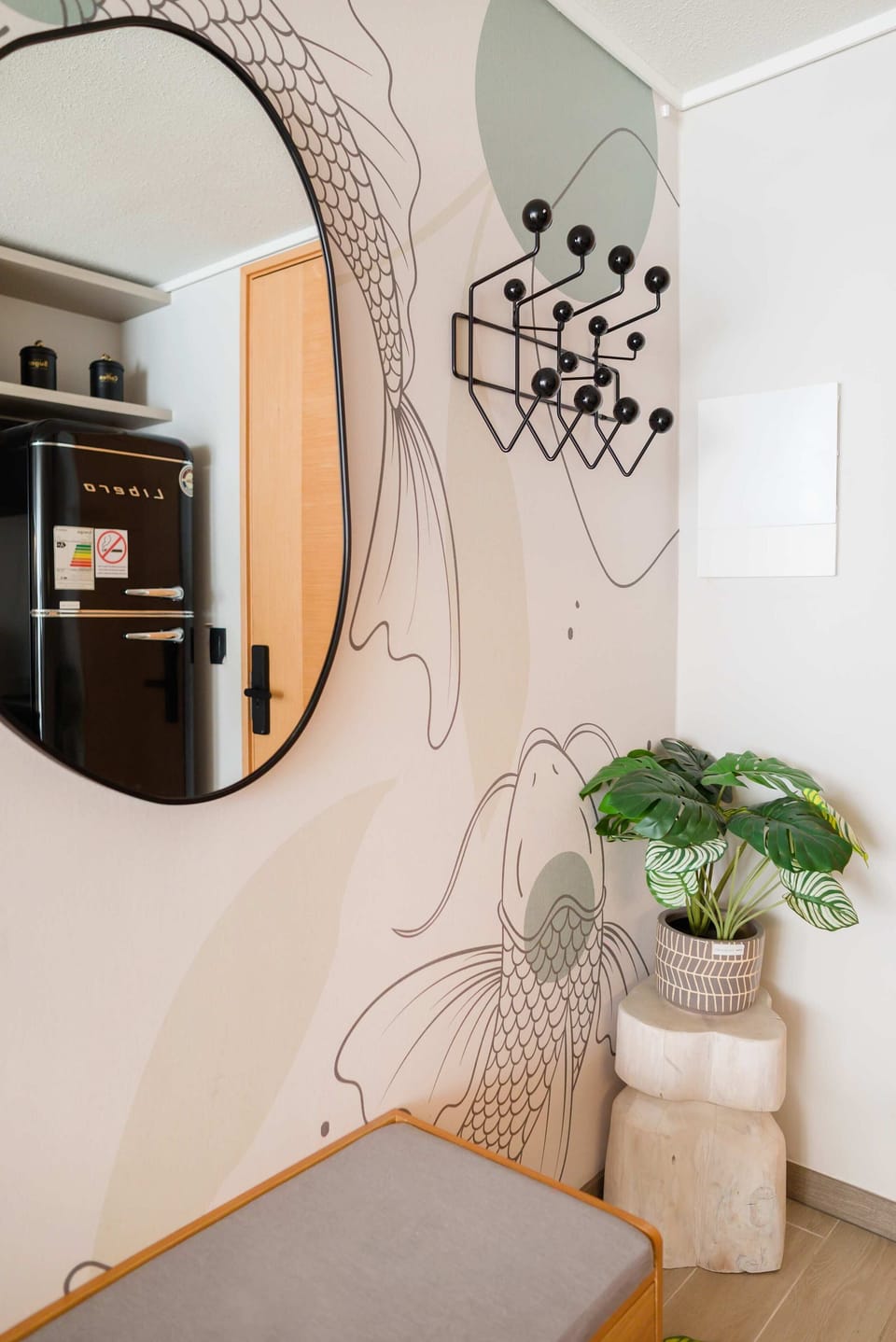 Stylish corner with modern decor and a retro fridge, perfect for a cozy stay in this chic studio.
