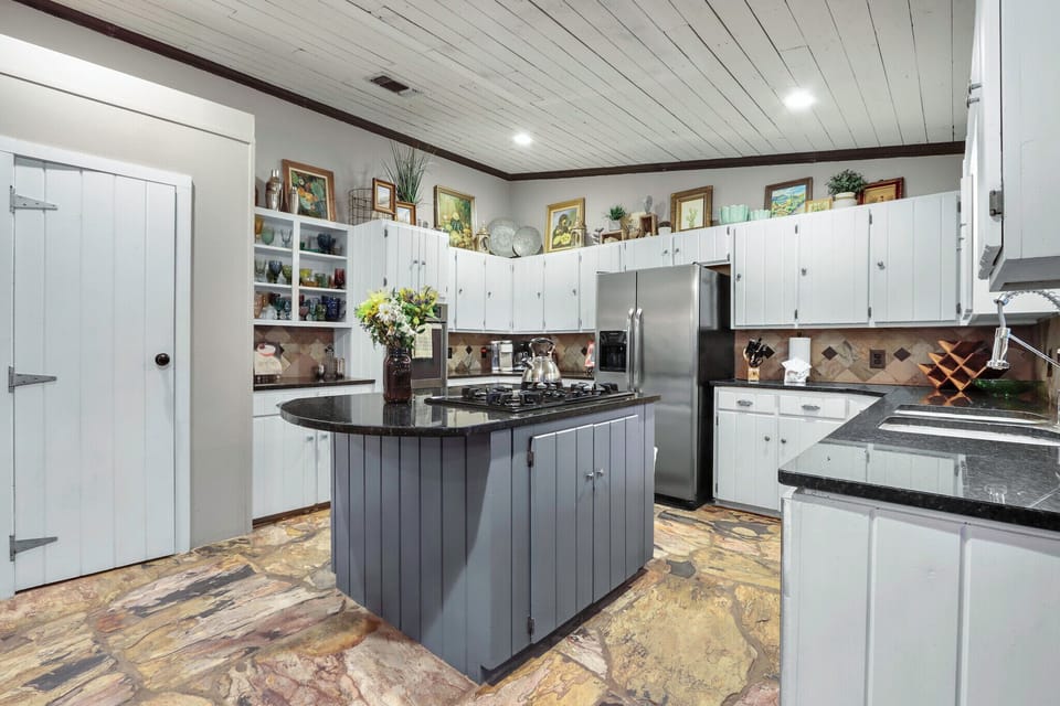 View of the kitchen with range, oven, microwave, and refrigerator