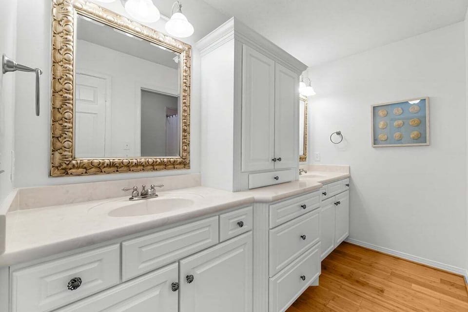 Primary bathroom with dual vanity and shower tub combo