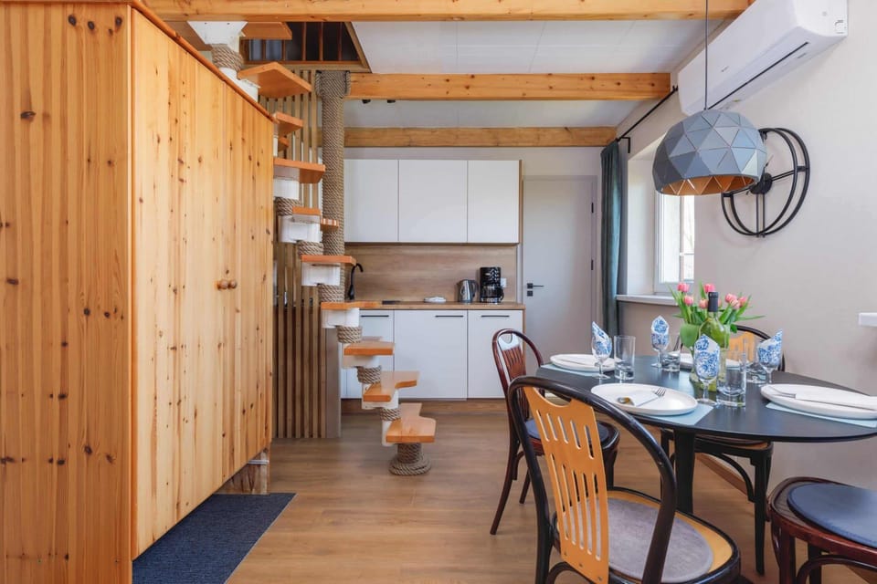 A dining area with wooden furniture and a spiral staircase leading to the upper level.
