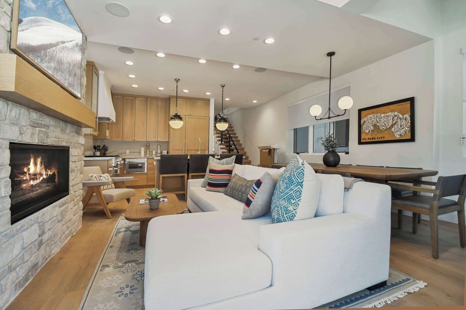 Cozy open-concept living area with a warm fireplace, modern kitchen, and spacious dining—perfect for relaxing, cooking, and gathering together.
