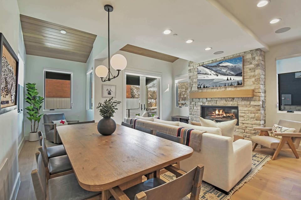 Warm and inviting living and dining space with a cozy fireplace, comfy seating, and plenty of natural light—perfect for relaxing and gathering.
