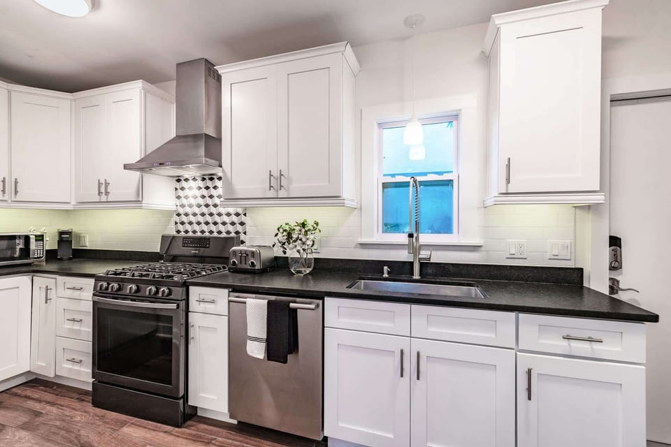 Modern white kitchen with stainless appliances and electric range (please note stove has been changed)