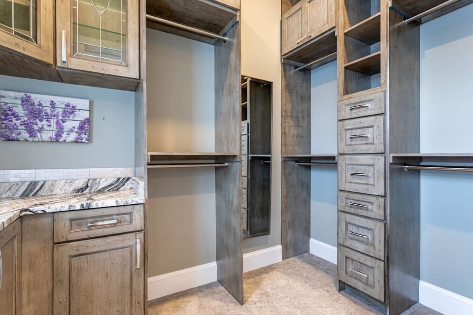 Walk-in closet with built-in shelving, hanging rods, and vanity counter