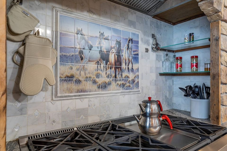 Kitchen backsplash featuring hand-painted horse tile mural above the gas range