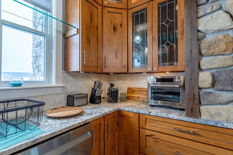 Kitchen counter with glass-front upper cabinets and small appliances
