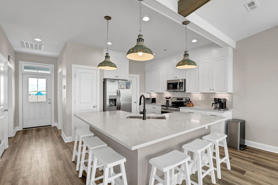 Bright kitchen with modern appliances and fixtures AND seating for many.
