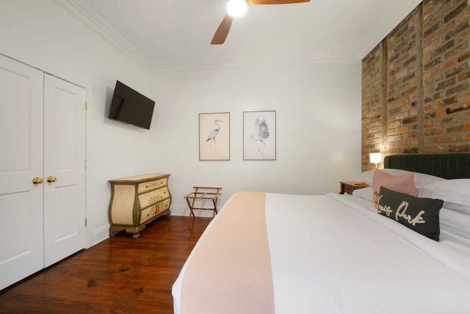 Elegant king bedroom with exposed brick walls and luxurious bedding