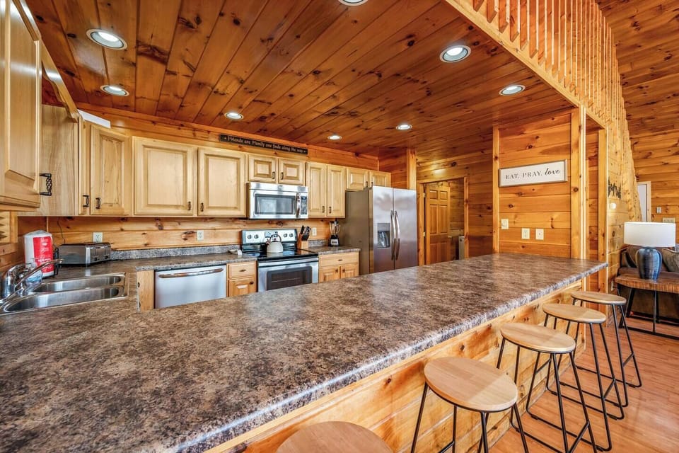 Large kitchen with stainless steel appliances and all utensils needed to cook and eat with. 