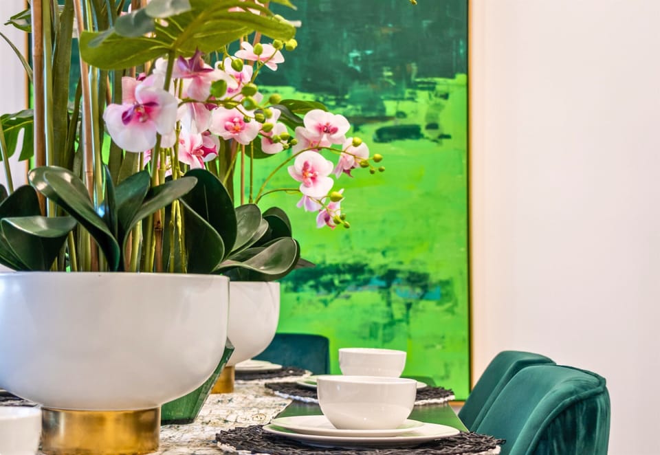 A close-up of the dining table beautifully styled with vibrant orchids and modern dishware, creating an inviting and elegant atmosphere for your next meal.