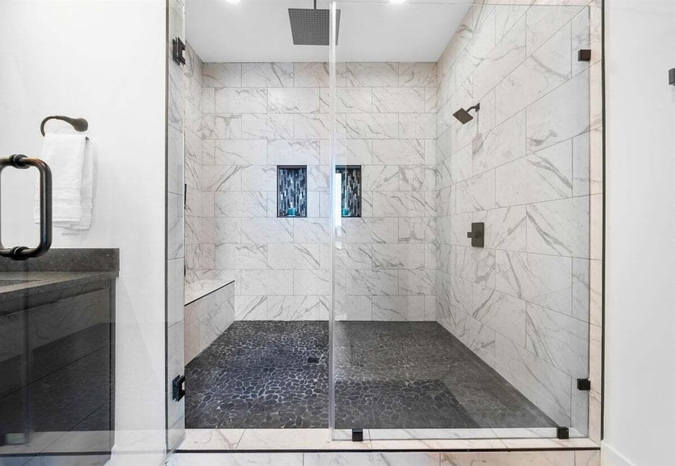 The walk-in shower is a highlight of this luxurious bathroom, with beautiful tilework and modern fixtures that create a serene, spa-like ambiance.