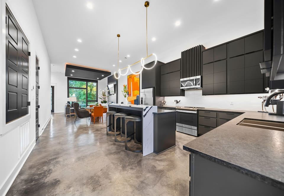 The open-concept layout showcases a sleek kitchen with high-end finishes, seamlessly flowing into the rest of the home for easy entertaining.