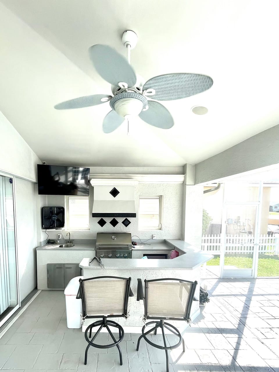 Outdoor kitchen area equipped with mini fridge and sink