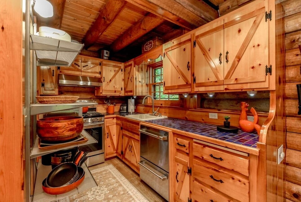 Well-equipped galley kitchen with gas range, dishwasher, and cookware.