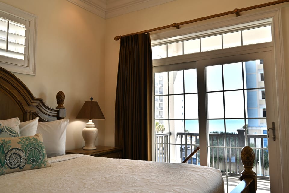 Comfortable bedroom with balcony access and ocean views