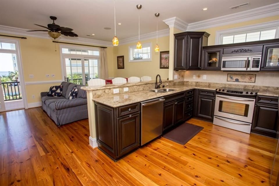 Spacious kitchen with island, stainless steel appliances & bar seating.