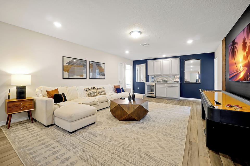 Relax in the modern lounge featuring a plush sectional, mini bar, and a shuffleboard table. Ideal for entertaining or unwinding after a day of adventures