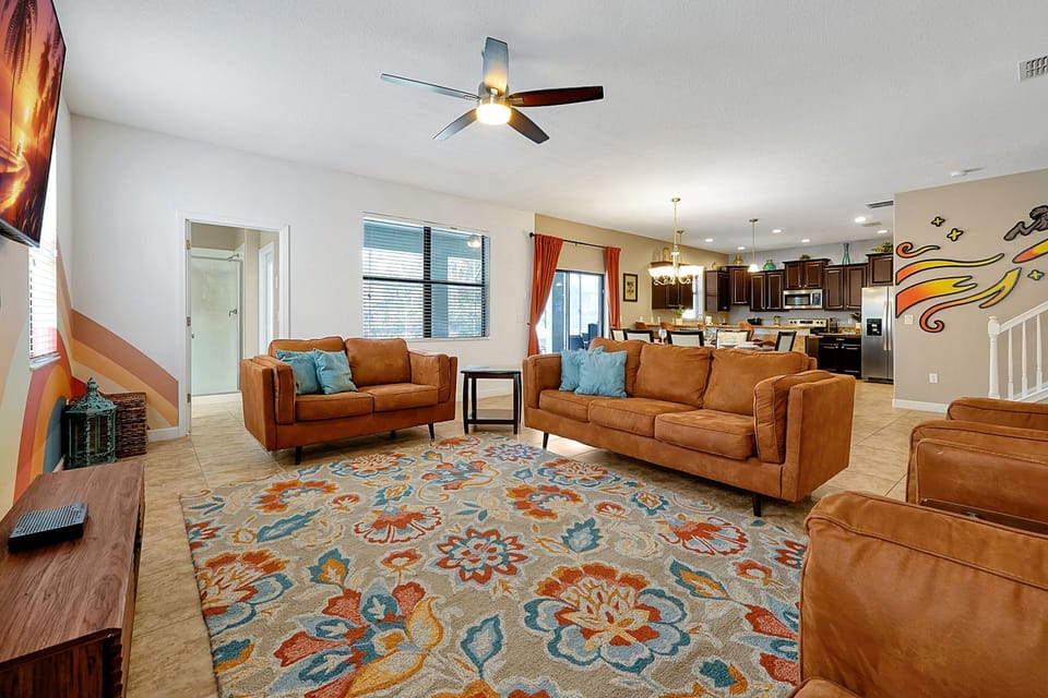 Open-concept living room with a unique mural, comfy seating, and plenty of space for family movie nights.