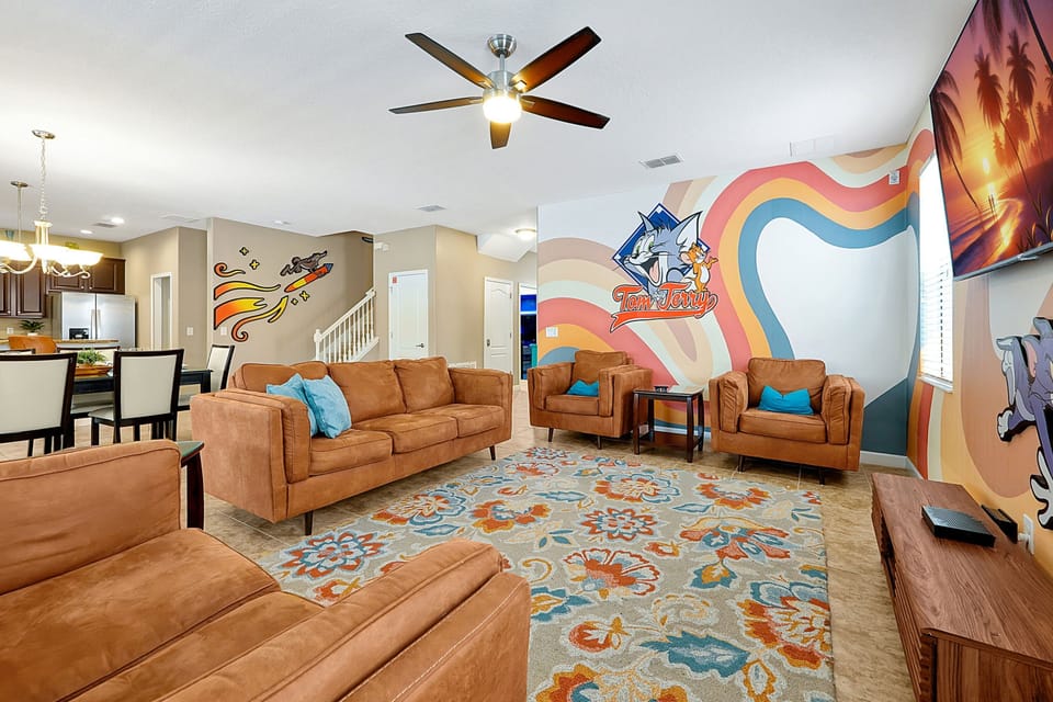 Open-concept living room with a unique mural, comfy seating, and plenty of space for family movie nights.