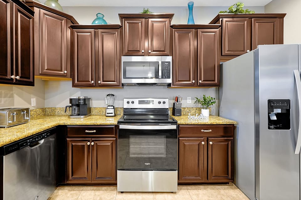ully equipped kitchen featuring stainless steel appliances, including a microwave and full-size refrigerator.