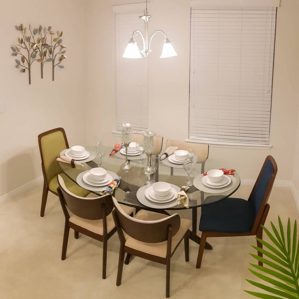 Join us at the elegant glass dining table, adorned with stylish dishware and colorful chairs. The soft lighting creates a warm atmosphere, ideal for enjoying meals and engaging conversations with your loved ones.