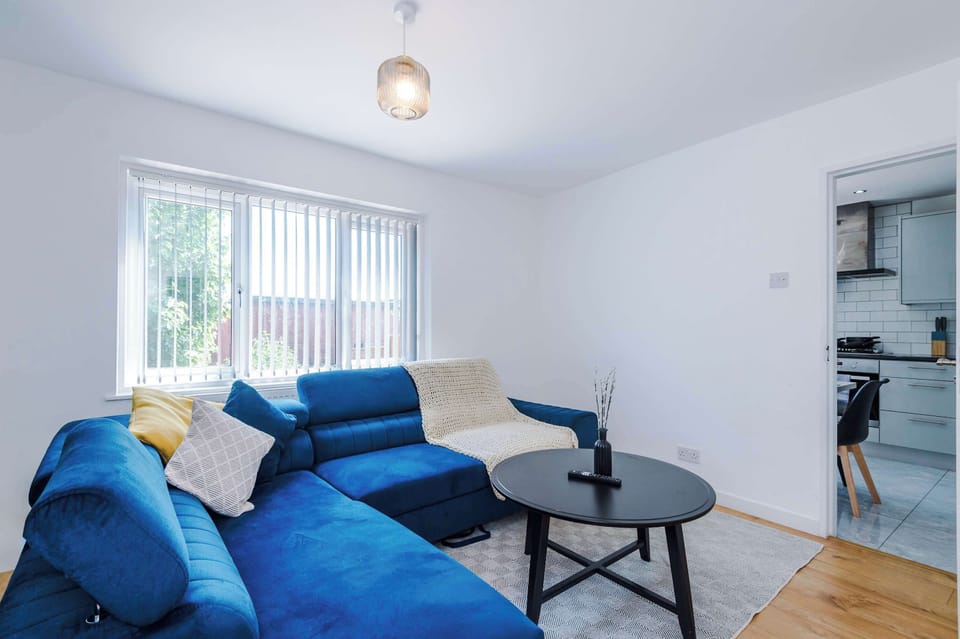 Large windows flood the seating area with natural light, highlighting the crisp white walls and modern wood-effect flooring.