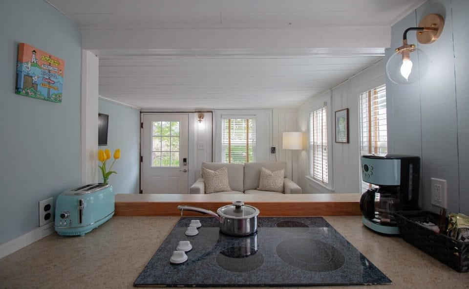 The kitchen includes an electric stovetop and oven, a medium-sized refrigerator, microwave, toaster, and a standard coffee maker for your convenience.