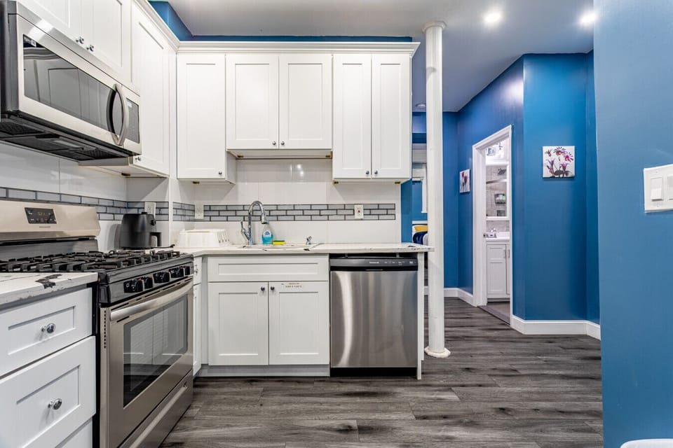 Modern kitchen — gas range, dishwasher, microwave, coffee maker.