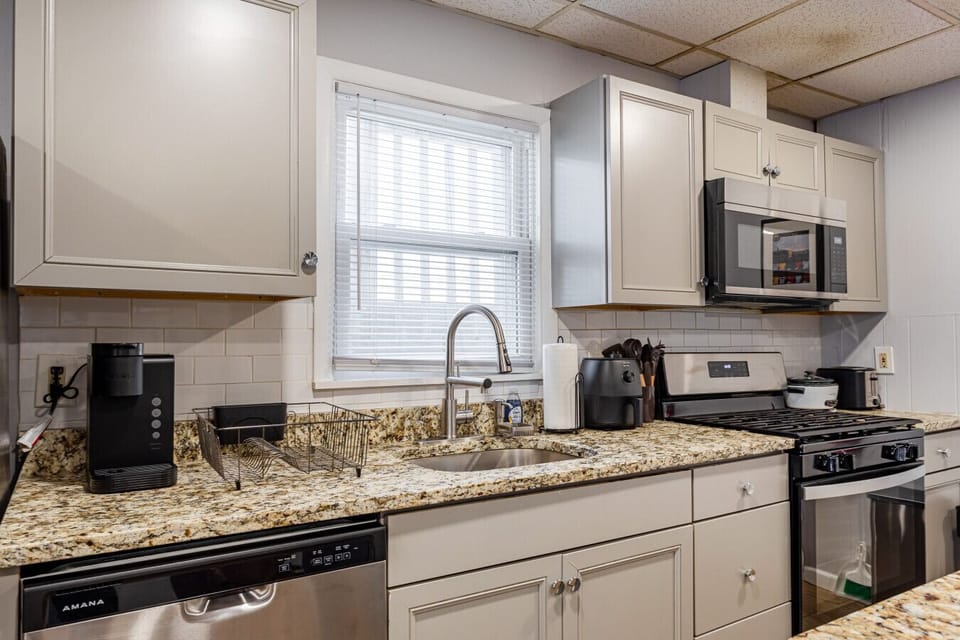 Fully-equipped kitchen with full-size fridge, gas range, dishwasher, microwave, and coffee maker.