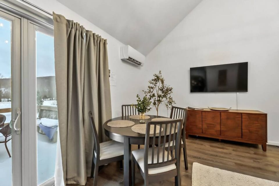 The dining area features a sleek table with four comfy seats.