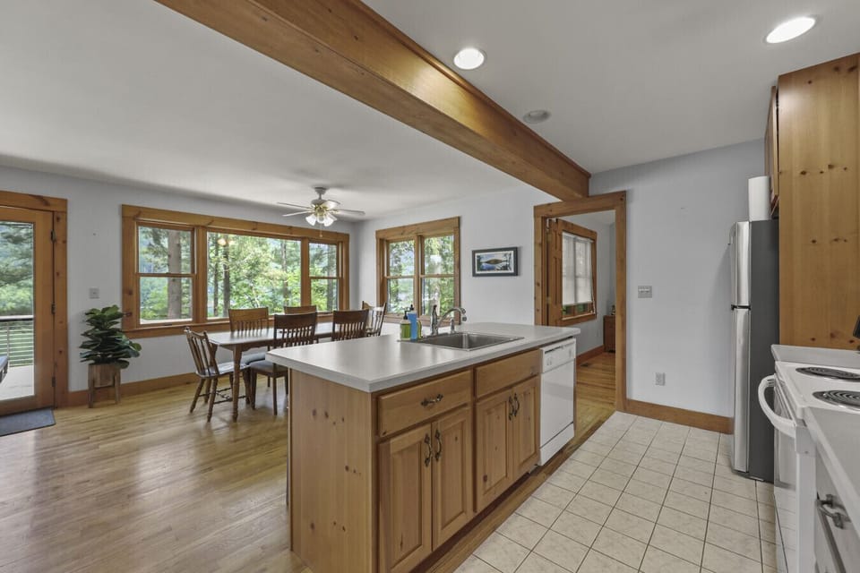 Galley-style kitchen and dining with wooden cabinets, full appliances, and efficient layout.