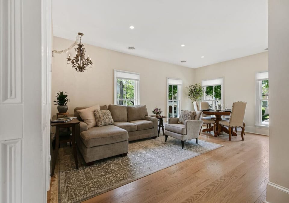 Combined area with dining table and a relaxed seating setup, surrounded by windows for natural light.
