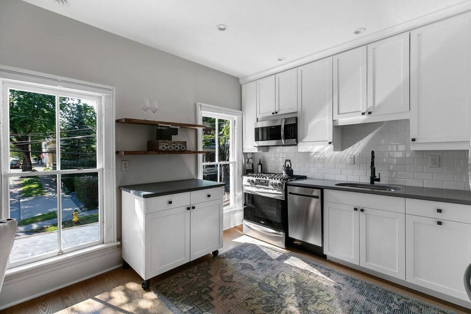 A bright, functional kitchen featuring a full range stove, microwave, dishwasher, and ample counter space.
