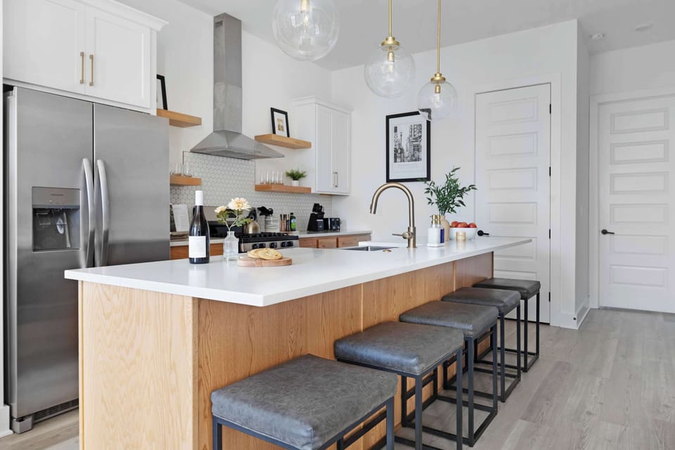 Modern kitchen with a spacious pantry and a large island with five barstools, ideal for cooking and casual dining