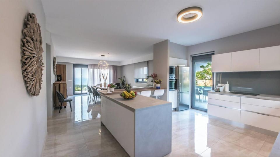Gather, cook, and connect — the open-plan kitchen and spacious dining table set the scene for shared moments with stunning views