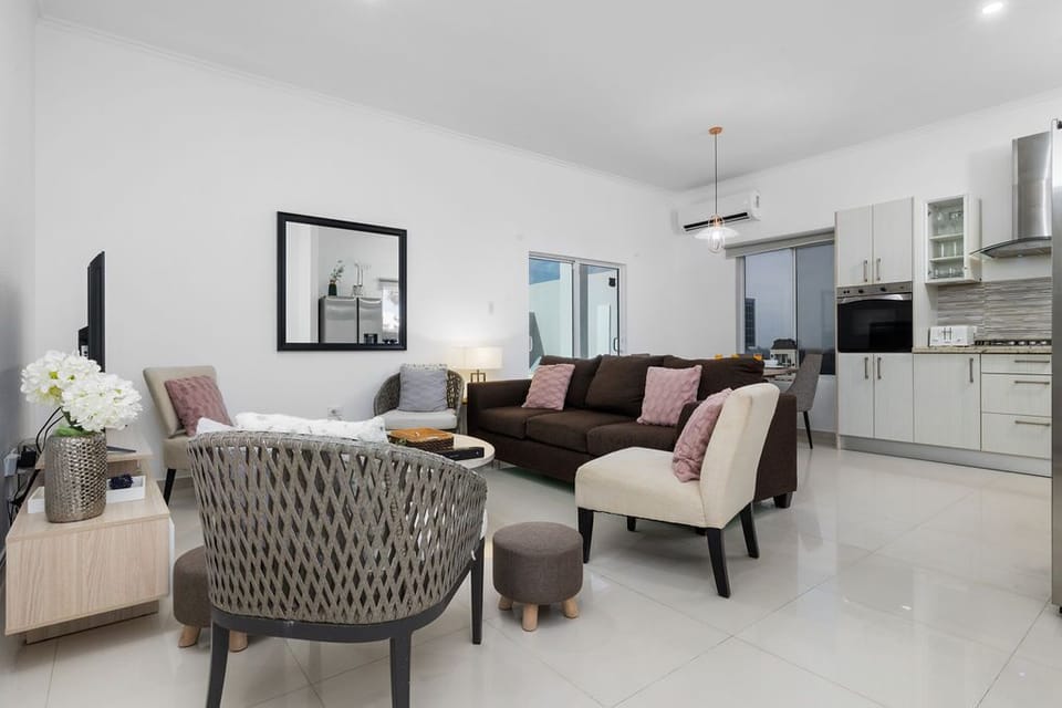 Unwind in your open-concept living space, where modern comforts meet relaxed style. Plush seating and a sleek kitchen await your arrival.