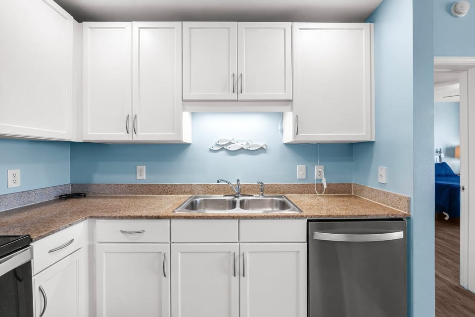 Modern kitchen with white cabinetry and stainless steel sink