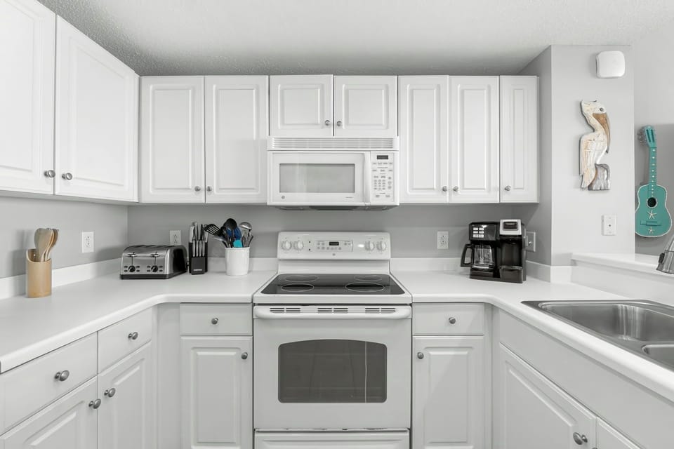 modern kitchen with white cabinetry and essential appliances for convenient cooking