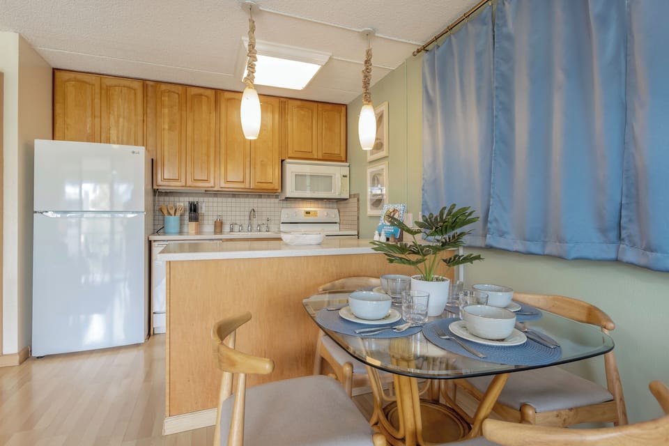 Open kitchen with dining table for 3 and views into the spacious living area and private lanai.